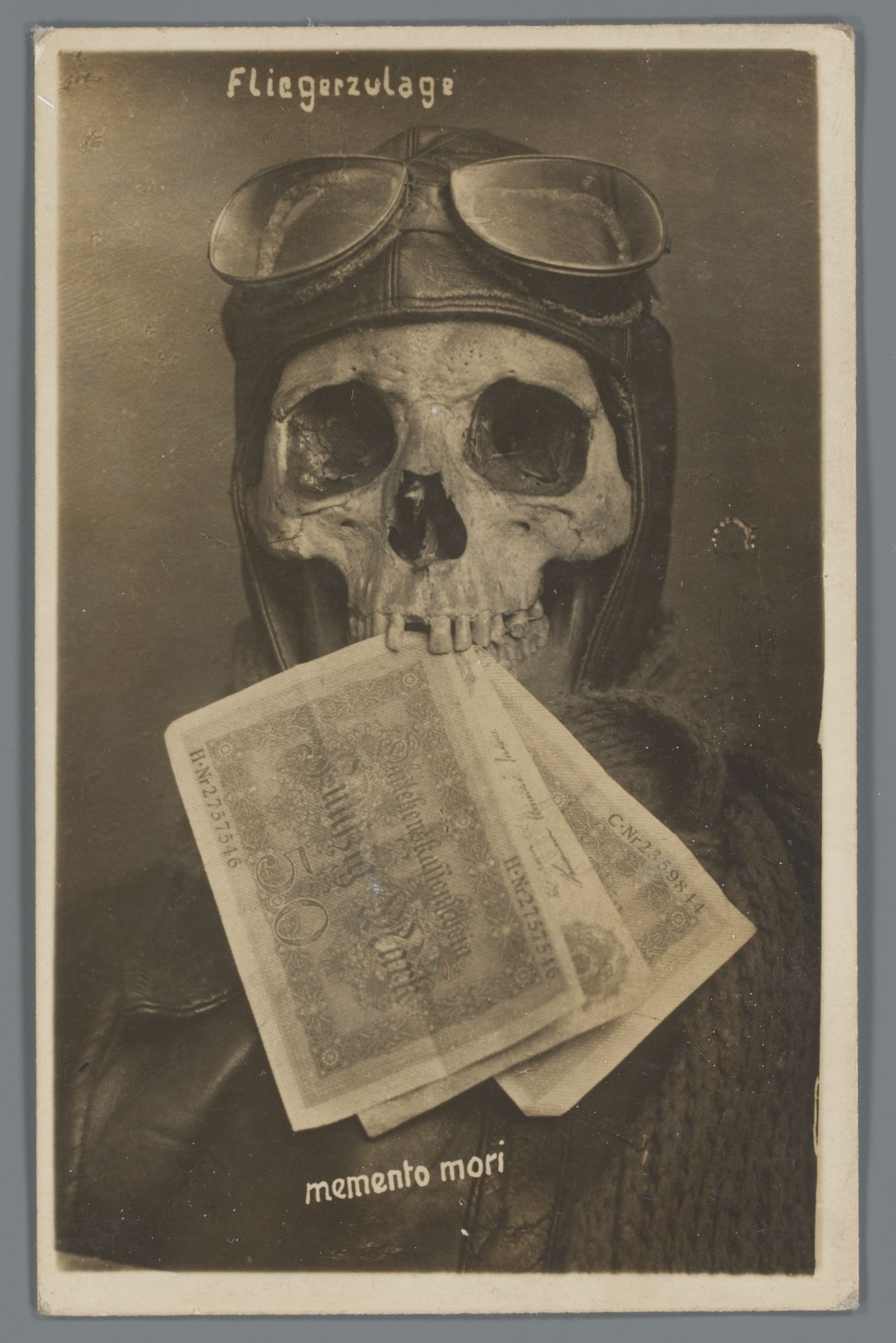 Doodshoofd met Duitse vliegenier, met bankbiljetten tussen de kaken geklemd